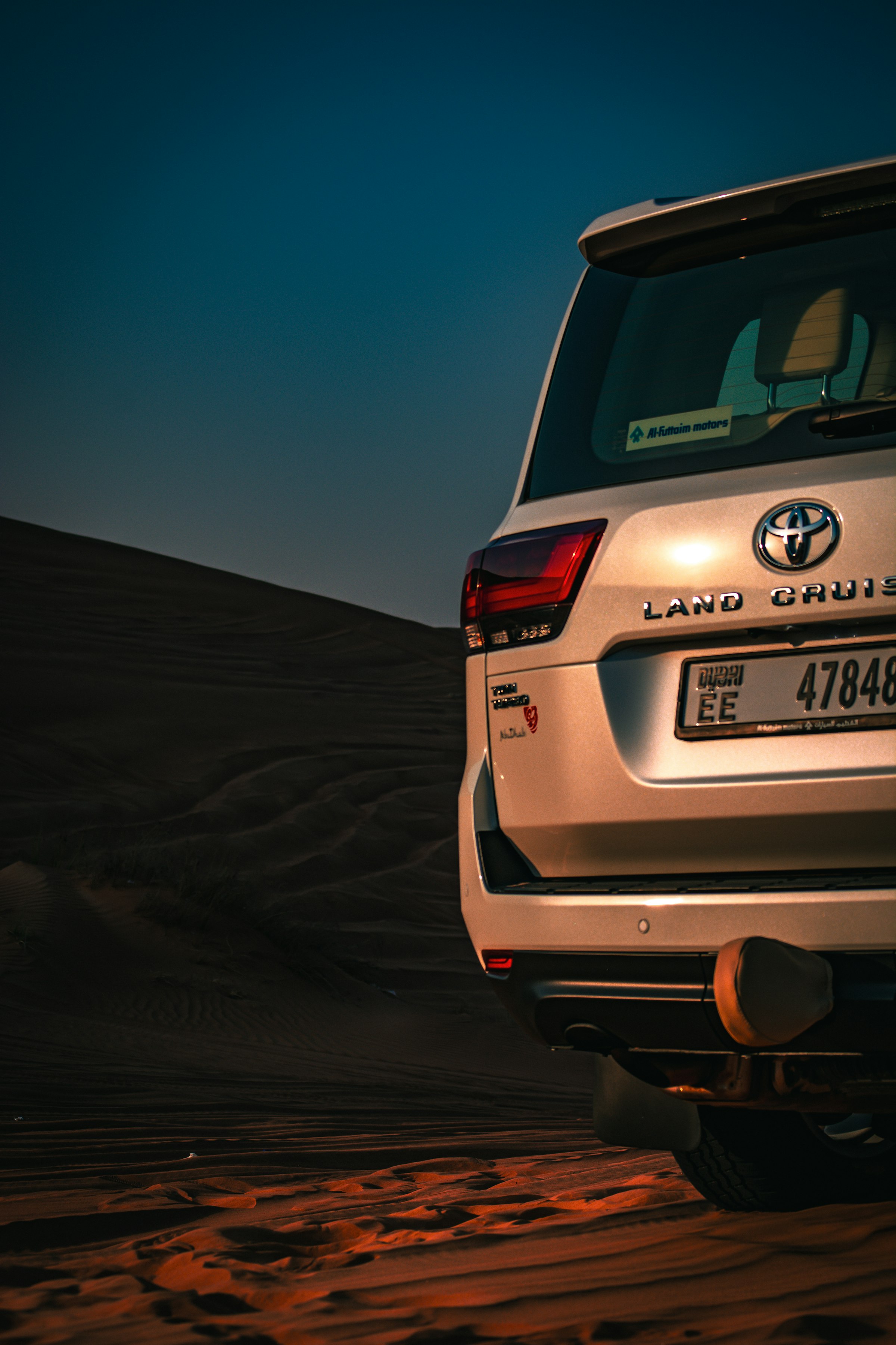 A four-wheel-drive vehicle crossing golden desert dunes on safari